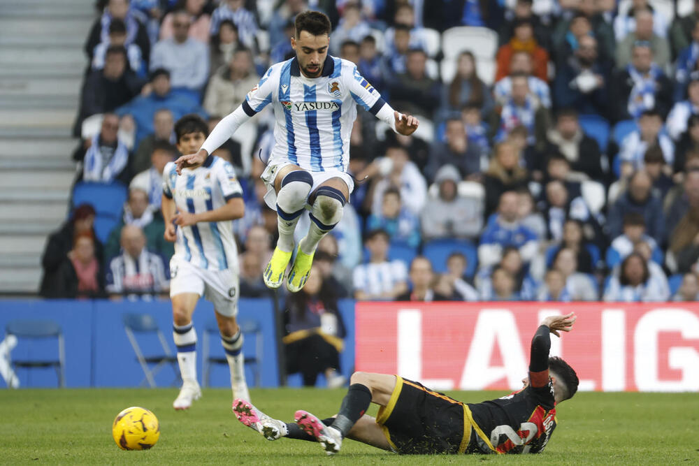 El centrocampista de la Real Sociedad Brais Méndez salta ante Óscar Valentín